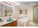 Bathroom with jacuzzi tub, separate shower, a ceramic sink and decorative vanity mirrors at 5774 Sioux Dr, Sedalia, CO 80135