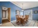 Bright dining room featuring blue walls, a wooden table set, and natural light from the sliding glass doors at 5774 Sioux Dr, Sedalia, CO 80135