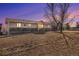 Charming home featuring covered porch, stone accents, garage and a mature tree at 5774 Sioux Dr, Sedalia, CO 80135