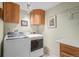 Modern laundry room with front loading washer and dryer, upper cabinets, and a folding table at 5774 Sioux Dr, Sedalia, CO 80135