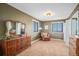 Bright main bedroom with neutral tones features a cozy sitting area by the window and an antique dresser at 5774 Sioux Dr, Sedalia, CO 80135