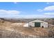 Property featuring large outbuilding with green doors and surrounding mountain views at 5774 Sioux Dr, Sedalia, CO 80135