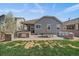 Outdoor backyard with a built-in stone grill, dining table, and comfortable seating for entertaining at 6747 W Jewell Pl, Lakewood, CO 80227