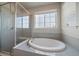 Bright bathroom with an oval soaking tub and glass enclosed shower at 6747 W Jewell Pl, Lakewood, CO 80227