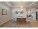 Bright dining room with a glass-top table, modern lighting, and a decorative wall at 6747 W Jewell Pl, Lakewood, CO 80227