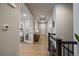 Upstairs hallway with wood floors, a view of the front door, a staircase, and a cabinet with a lamp at 6747 W Jewell Pl, Lakewood, CO 80227