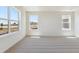 Bright bedroom featuring tan carpet, white walls, and baseboard trim, with a view at 2256 Base St, Fort Lupton, CO 80621