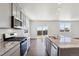 Bright kitchen featuring stainless steel appliances, granite countertops, and a view of the backyard at 2256 Base St, Fort Lupton, CO 80621