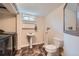 Basement bathroom featuring classic fixtures, a pedestal sink, and updated flooring next to the laundry area at 15835 E Oxford Ave, Aurora, CO 80013