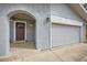 Welcoming front entry with arched entryway, two-car garage and updated carriage-style lighting at 15835 E Oxford Ave, Aurora, CO 80013