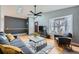 Bright living room with hardwood floors, a ceiling fan, a bay window, and staircase access to the second level at 15835 E Oxford Ave, Aurora, CO 80013