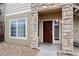 Inviting front entrance with stone accents and a charming red door at 9961 E Idaho Cir # 104, Aurora, CO 80247
