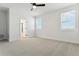 Bright main bedroom with plush carpet, two windows, and an ensuite bathroom at 42976 Colonial Trl, Elizabeth, CO 80107
