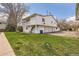 Rear view of the townhome featuring multiple garage spaces and a well-maintained backyard at 62 Newark St # C, Aurora, CO 80012