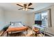Cozy bedroom with hardwood floors, a ceiling fan, a comfortable bed, and a well-lit workspace at 62 Newark St # C, Aurora, CO 80012
