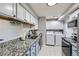 Efficient kitchen featuring modern appliances, granite countertops, and convenient laundry area at 62 Newark St # C, Aurora, CO 80012