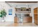 Modern bar area with wood cabinets, open shelving, and a wine fridge at 427 Whispering Pines Cir, Breckenridge, CO 80424