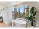Spa-like bathroom featuring a soaking tub, stylish fixtures, and picturesque forest views at 427 Whispering Pines Cir, Breckenridge, CO 80424