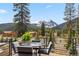 Outdoor dining area with mountain views on a spacious deck with seating for four people at 427 Whispering Pines Cir, Breckenridge, CO 80424