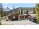 Inviting mountain home with a modern design, covered entrance, and spacious driveway at 427 Whispering Pines Cir, Breckenridge, CO 80424