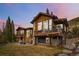 Stunning wood and stone home featuring a patio, expansive windows, and a mountain view at 427 Whispering Pines Cir, Breckenridge, CO 80424