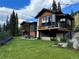 Stunning multi-story home with balconies and a stone chimney, overlooking lush green lawns at 427 Whispering Pines Cir, Breckenridge, CO 80424