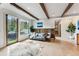 Open living room featuring hardwood floors, wooden beams, and large windows showcasing outdoor views at 427 Whispering Pines Cir, Breckenridge, CO 80424