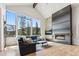 Sunlit living room with mountain view through large windows and modern fireplace at 427 Whispering Pines Cir, Breckenridge, CO 80424
