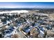 Aerial view of homes, roads, and a lake in a snowy neighborhood at 4268 S Andes Way, Aurora, CO 80013