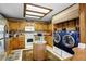 Functional kitchen includes wood cabinetry, a center island, modern appliances, and a convenient laundry area at 214 Poppy St, Golden, CO 80401