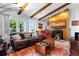 Bright living room featuring exposed beam ceiling, fireplace, and a large window, creating a warm and inviting atmosphere at 214 Poppy St, Golden, CO 80401