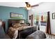 Bright main bedroom featuring a large bed, accent wall, ceiling fan, and window views at 214 Poppy St, Golden, CO 80401