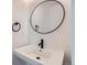 Sleek powder room features a modern sink with a black faucet and round mirror at 10151 W 38Th Ave, Wheat Ridge, CO 80033