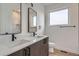 Stylish bathroom with dual sinks, wood-look cabinets, and a view of the tiled shower at 10151 W 38Th Ave, Wheat Ridge, CO 80033