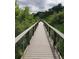 A wooden boardwalk winds through a lush, green wetland area at 10151 W 38Th Ave, Wheat Ridge, CO 80033