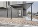 Covered entrance with modern door and dark brick accents, complemented by decorative rock landscaping at 10151 W 38Th Ave, Wheat Ridge, CO 80033