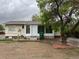 Exterior shot of back of the house with mature tree at 405 Dogwood Ave, Brighton, CO 80601