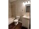 Bathroom featuring a tub, toilet, and vanity, complemented by neutral-toned walls and wood-look flooring at 405 Dogwood Ave, Brighton, CO 80601