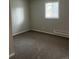 Bedroom features a window that lets in natural light and neutral-toned walls and carpet at 405 Dogwood Ave, Brighton, CO 80601