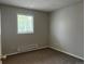 Bedroom featuring a window that lets in natural light and neutral-toned walls and carpet at 405 Dogwood Ave, Brighton, CO 80601