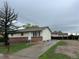 Cozy single-story home with a brick foundation, concrete driveway, and spacious front yard, perfect for outdoor activities at 405 Dogwood Ave, Brighton, CO 80601