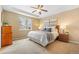 A well-lit bedroom with a cozy bed, neutral colors, and a ceiling fan at 2897 Hillcroft Ln, Castle Rock, CO 80104