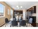 Chic dining area with access to the kitchen featuring a glass table and modern chandelier at 2897 Hillcroft Ln, Castle Rock, CO 80104