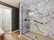 This bathroom features a newly remodeled glass-enclosed shower with marbled tiling at 3812 Red Deer Trl # D, Broomfield, CO 80020