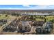 Aerial view of the community with mature trees and a pond, set against the backdrop of distant mountains under a blue sky at 4625 W 50Th Ave # 110, Denver, CO 80212