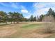 Golf course view featuring a green with flag, manicured grounds, trees and blue sky with clouds at 4625 W 50Th Ave # 110, Denver, CO 80212