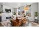 Modern living room showcasing a fireplace, stylish seating, and a unique bar-height table with stools at 4625 W 50Th Ave # 110, Denver, CO 80212