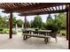 Outdoor patio with pergola, dining table, and seating area, overlooking the pool and backyard at 6200 Charrington Dr, Cherry Hills Village, CO 80111