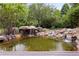 Serene backyard pond with waterfall and lush landscaping at 6200 Charrington Dr, Cherry Hills Village, CO 80111