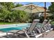 Inviting swimming pool with multiple lounge chairs and umbrellas at 6200 Charrington Dr, Cherry Hills Village, CO 80111